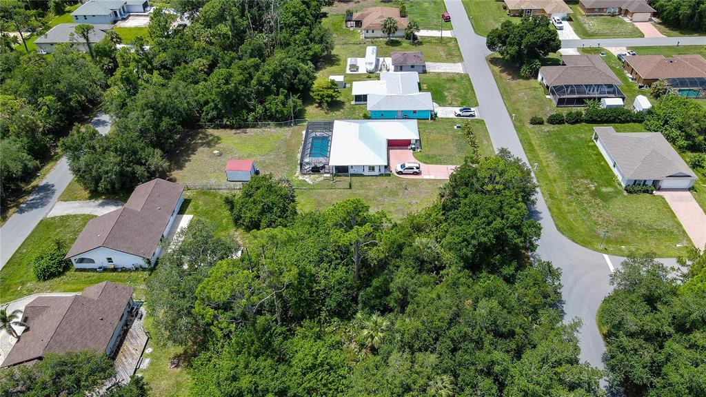 An aerial view shows several suburban houses with swimming pools and surrounding trees — 3388 HAMPTON STREET, PORT CHARLOTTE, FL