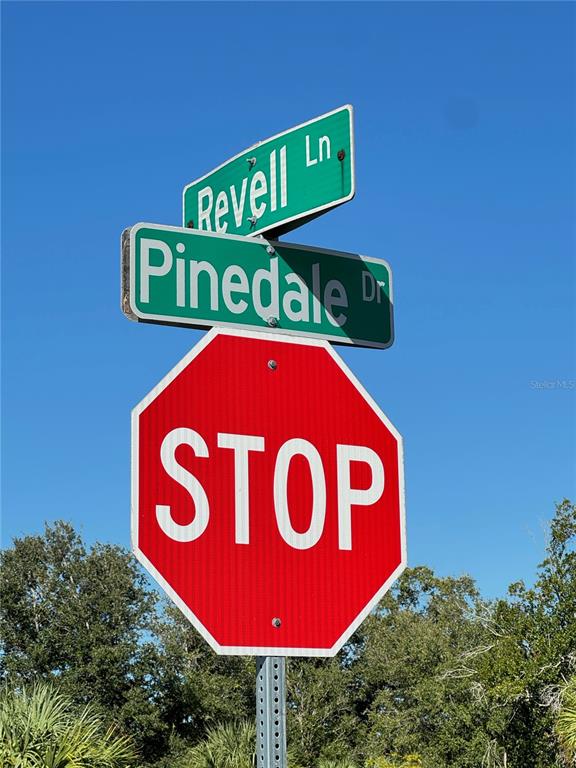 A stop sign stands below street signs for Revell Lane and Pinedale Drive — 13125 REVELL LANE, PORT CHARLOTTE, FL