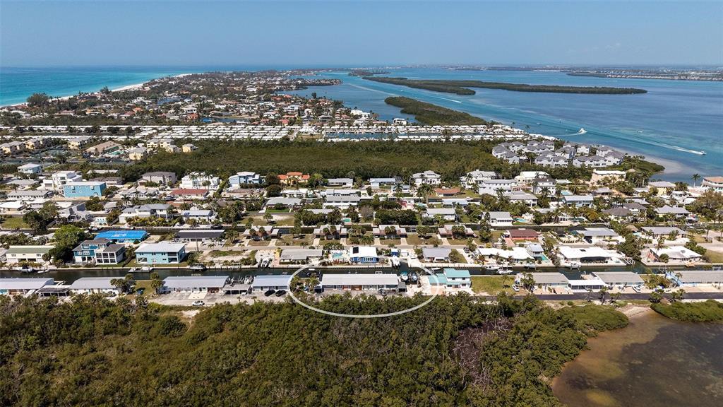 An aerial view shows a residential waterfront property circled in a coastal neighborhood — 729 SAINT JUDES DRIVE S UNIT 3, LONGBOAT KEY, FL
