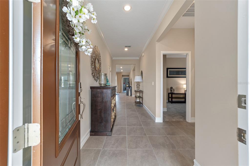 A tiled entryway leads into a hallway with a dark wood cabinet and arched doorways — 5521 NW 45TH LANE, OCALA, FL