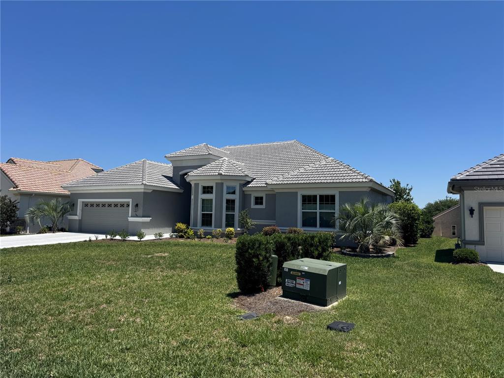 A single-story gray house with a tiled roof and a green utility box in front — 1745 N COMMONWEALTH WAY, HERNANDO, FL