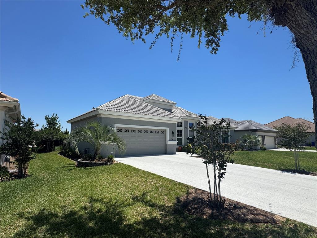 A single-story house with a gray exterior, a two-car garage, and a concrete driveway — 1745 N COMMONWEALTH WAY, HERNANDO, FL