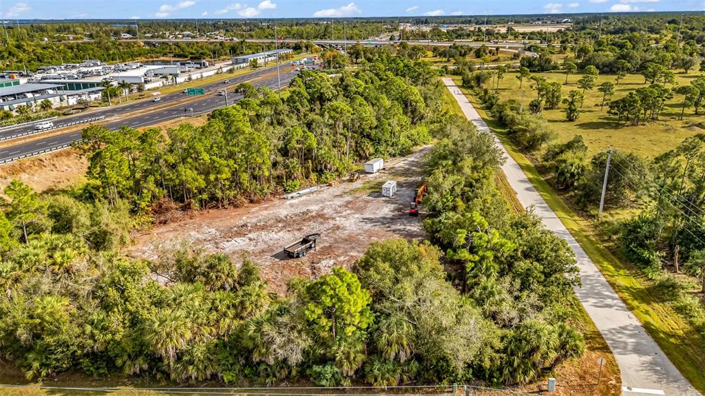 An aerial view shows a cleared dirt lot surrounded by trees near a highway — Unnamed US17 I75 EXIT 164 STREET, PUNTA GORDA, FL