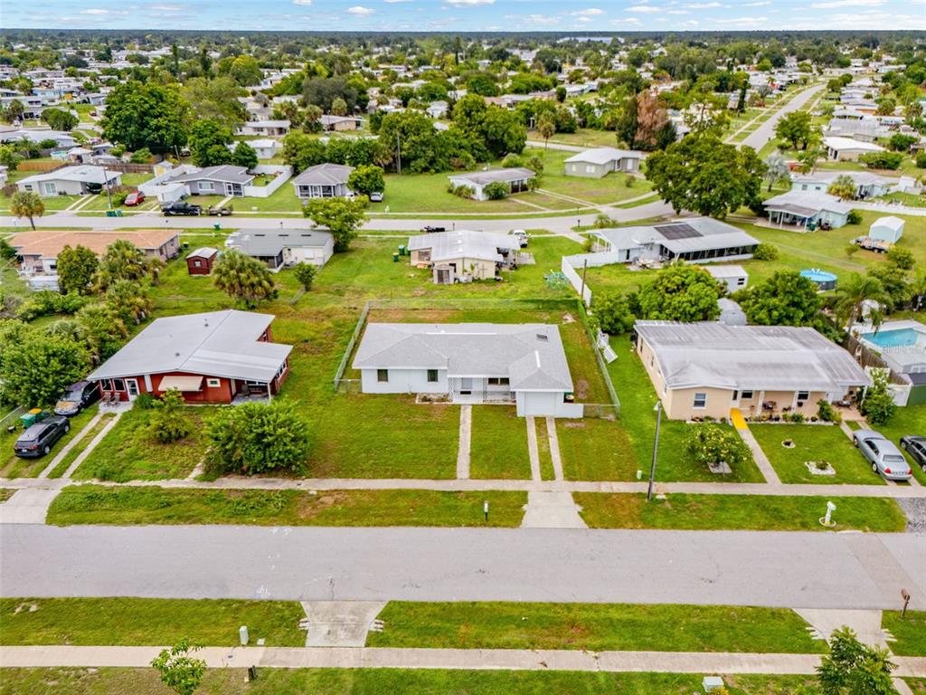 An aerial view shows a residential street with several single-story houses and green lawns — 21928 BEVERLY AVENUE, PORT CHARLOTTE, FL
