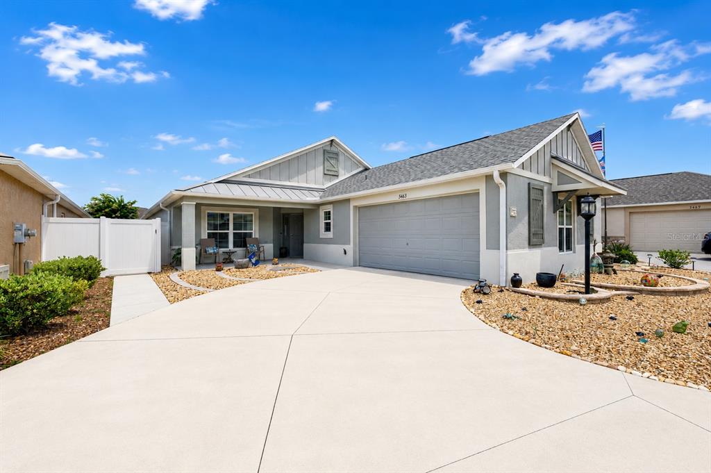 A single-story house with a gray garage, light-colored siding, and a gravel front yard — 3463 LEELANAU COURT, THE VILLAGES, FL