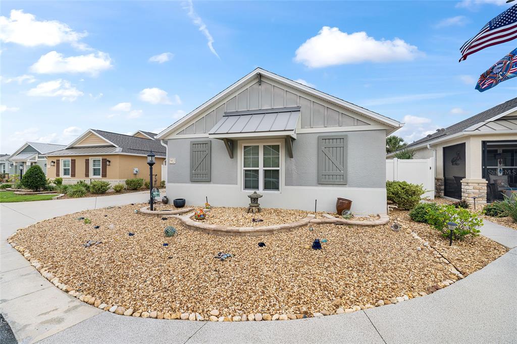 A single-story house with a gravel front yard and a curved stone retaining wall — 3463 LEELANAU COURT, THE VILLAGES, FL
