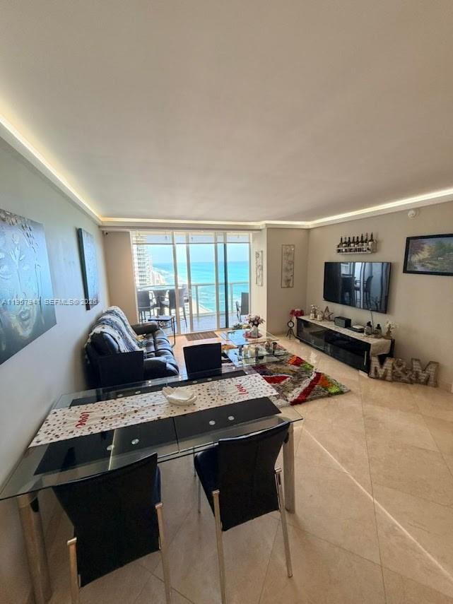 A living and dining area features tile floors, a glass table, and a balcony view — 1830 S Ocean Dr # 3810, Hallandale Beach FL 33009, HALLANDALE BEACH, FL
