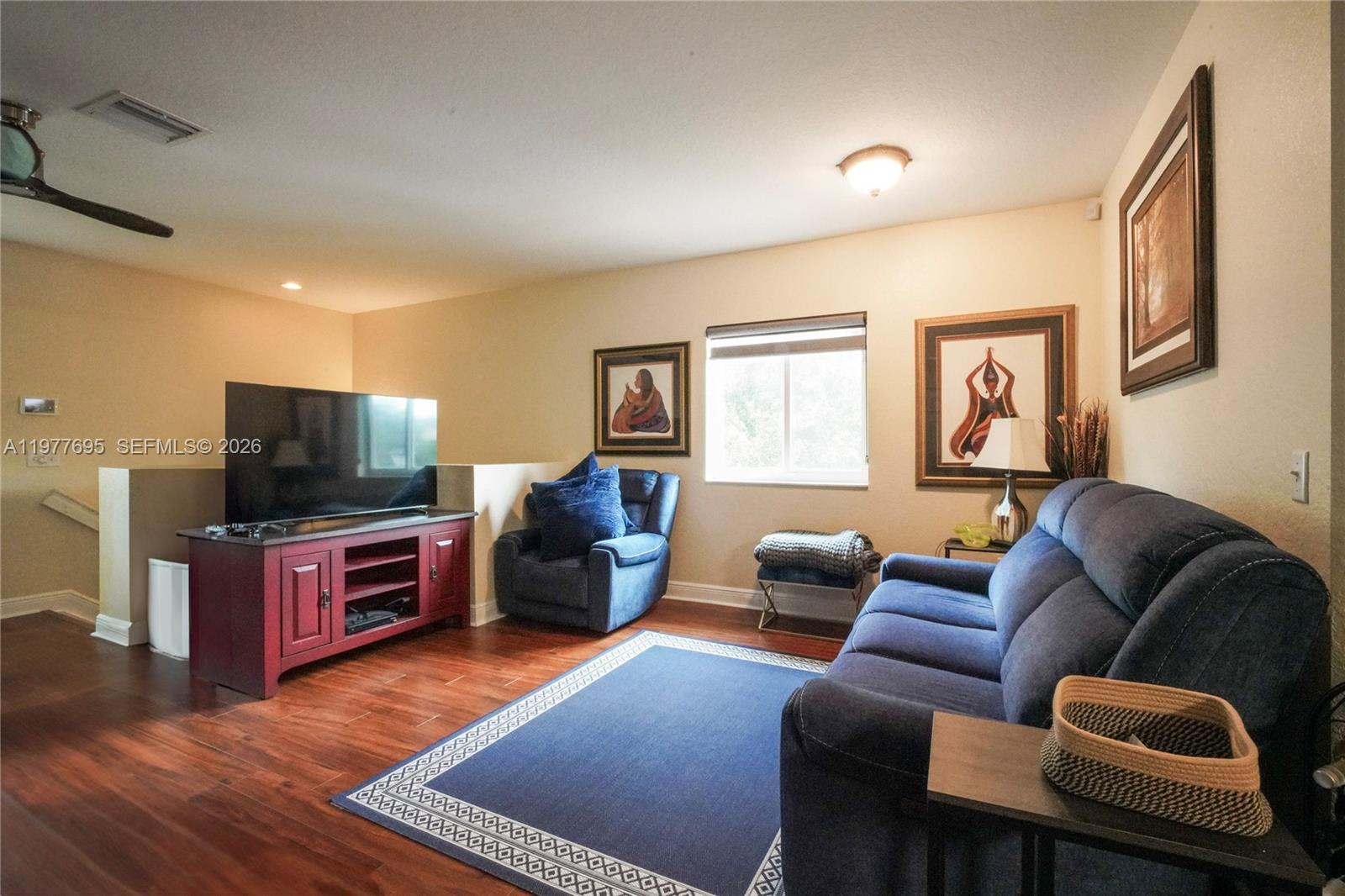 A living room features a blue sofa, a matching armchair, and a red media console — 3335 Palomino Dr # 3, Davie FL 33024, DAVIE, FL