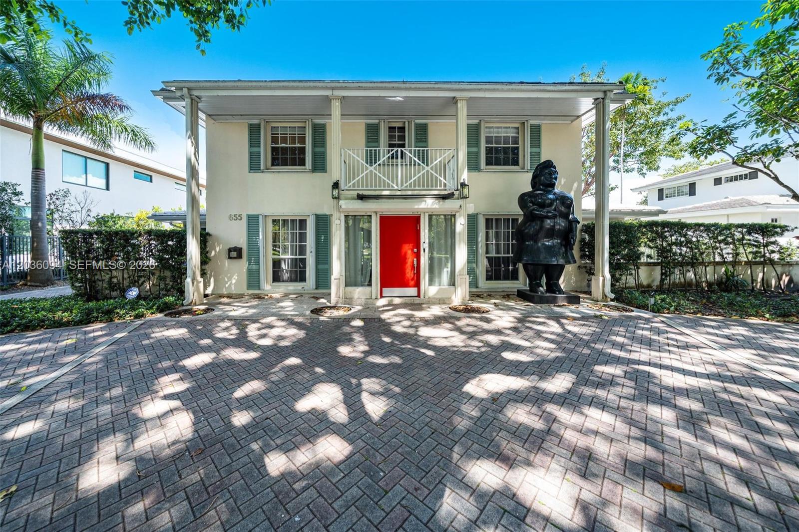 A two-story house features a red front door and a large black statue outside — 655 Buttonwood Ln, Miami FL 33137, MIAMI, FL
