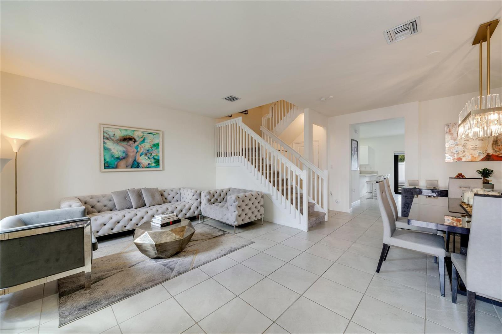 A row of townhouses with stucco facades, stone accents, and arched entryways faces a parking lot — 11392 W 34th Way, Hialeah FL 33018, HIALEAH, FL