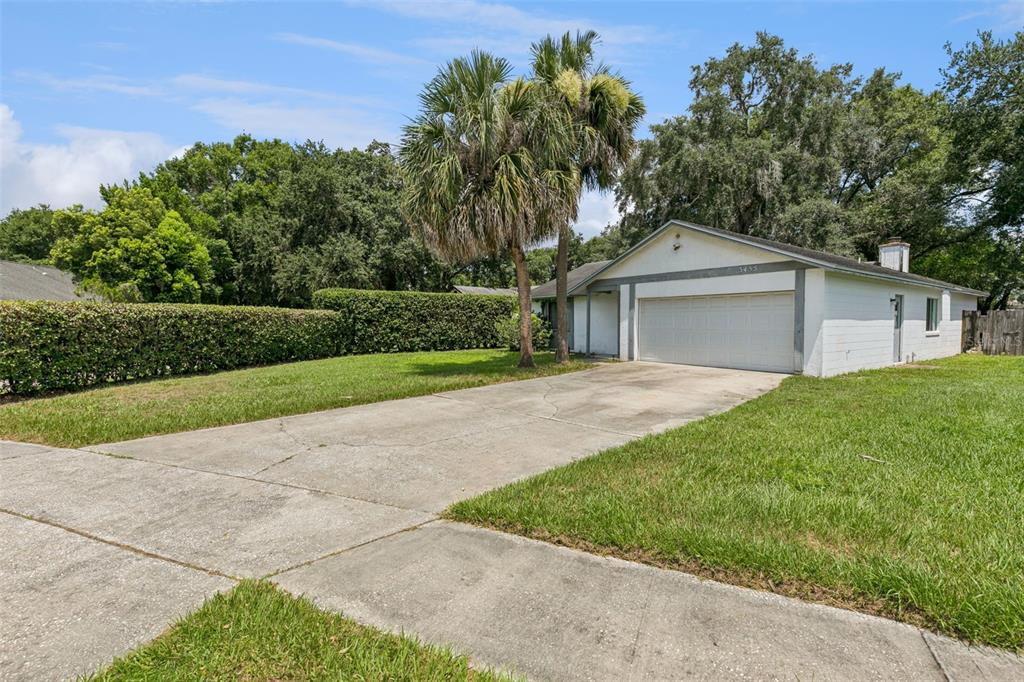 A single-story house with a white exterior, a two-car garage, and a large palm tree — 3455 JUJUBE DRIVE, ORLANDO, FL