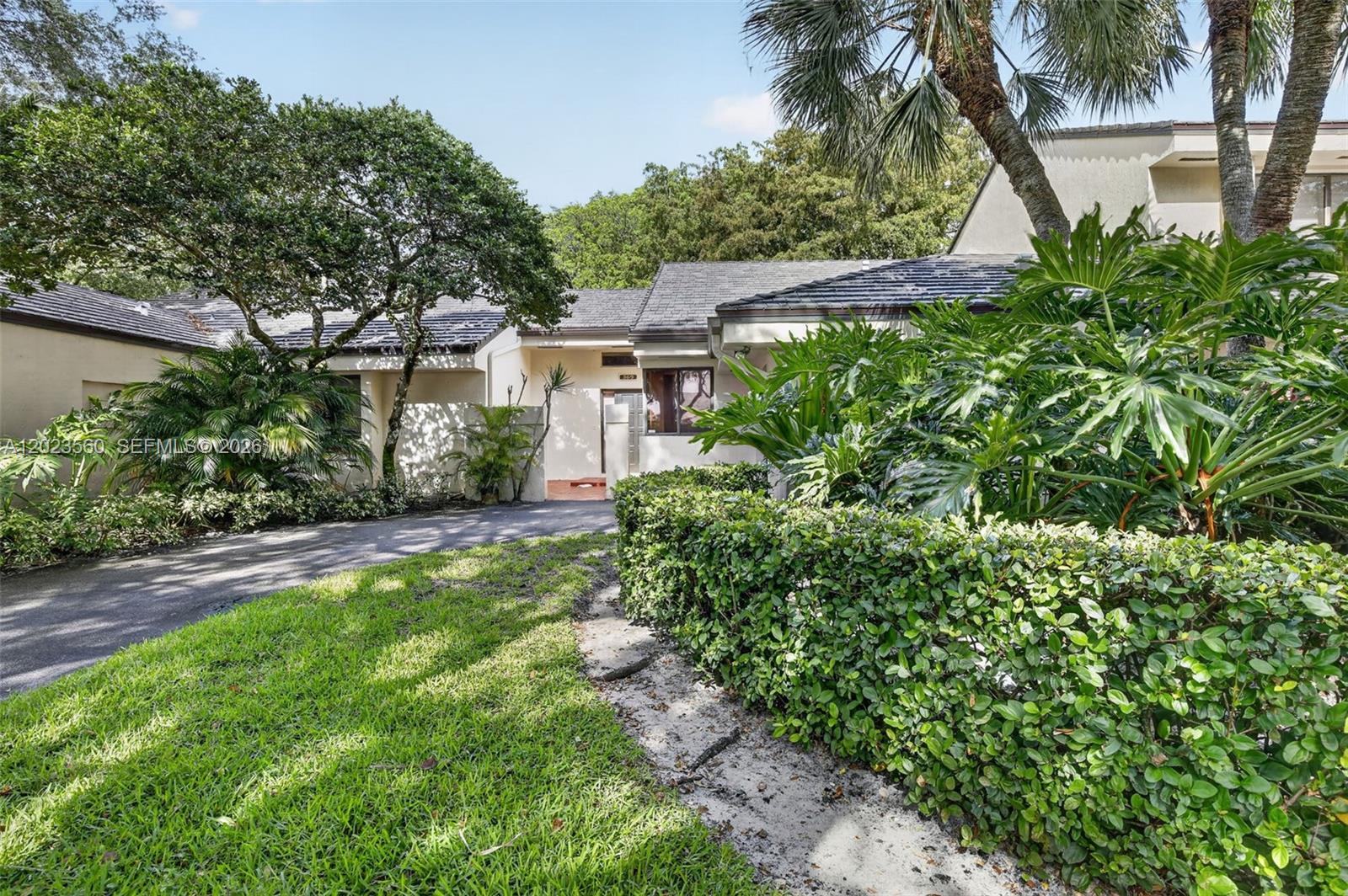 A paved driveway leads to the entrance of a single-story home with lush landscaping — 369 NW 97th Ave, Plantation FL 33324, PLANTATION, FL