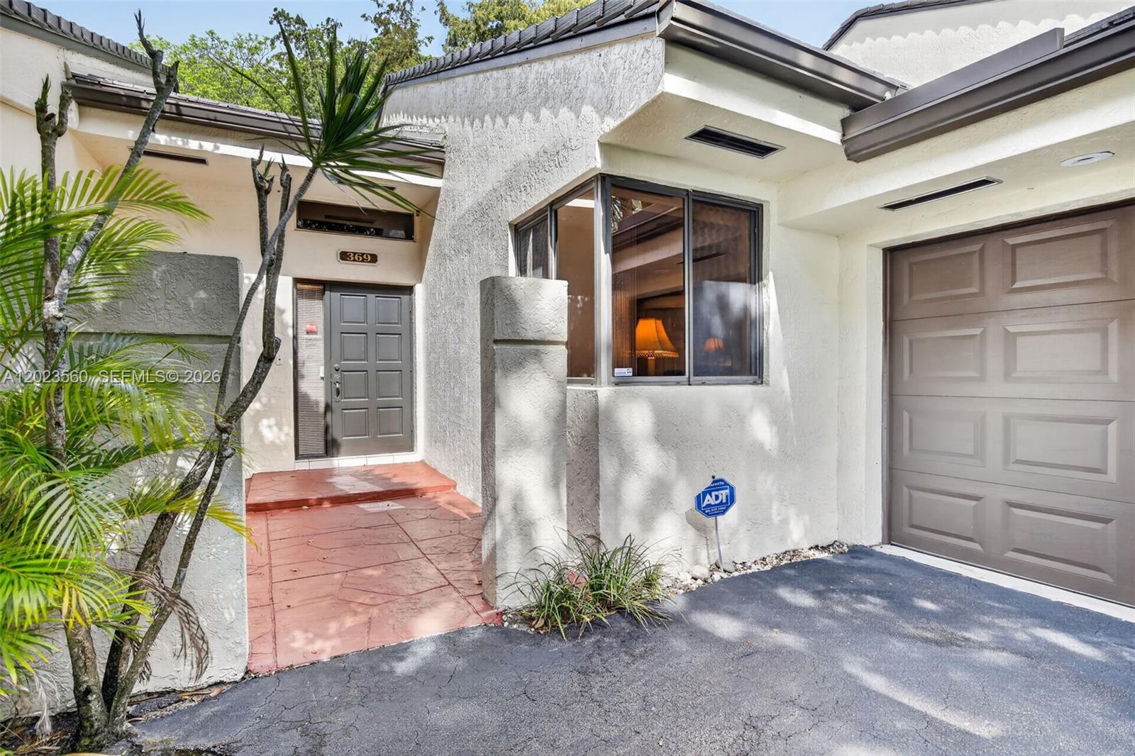 The exterior of a house features a brown front door, a garage, and a bay window — 369 NW 97th Ave, Plantation FL 33324, PLANTATION, FL