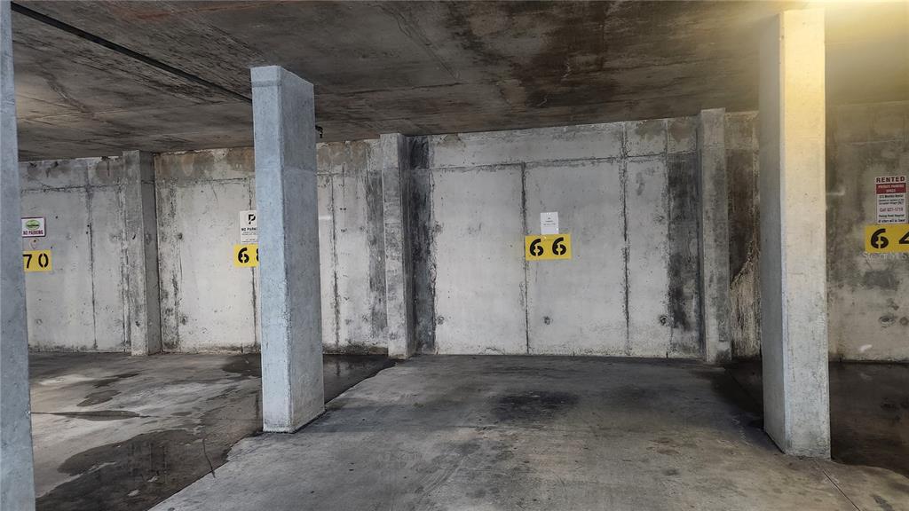 An indoor parking garage features concrete walls and pillars with numbered parking spaces — 101 PALM HARBOR PARKWAY UNIT P066, PALM COAST, FL