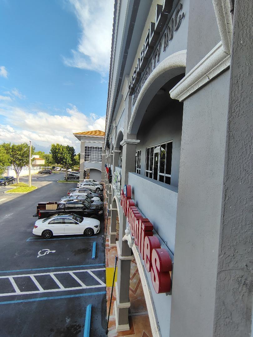 An exterior view shows a commercial building with a covered walkway and a parking lot — 14285 SW 42nd St # 211, Miami FL 33175, MIAMI, FL