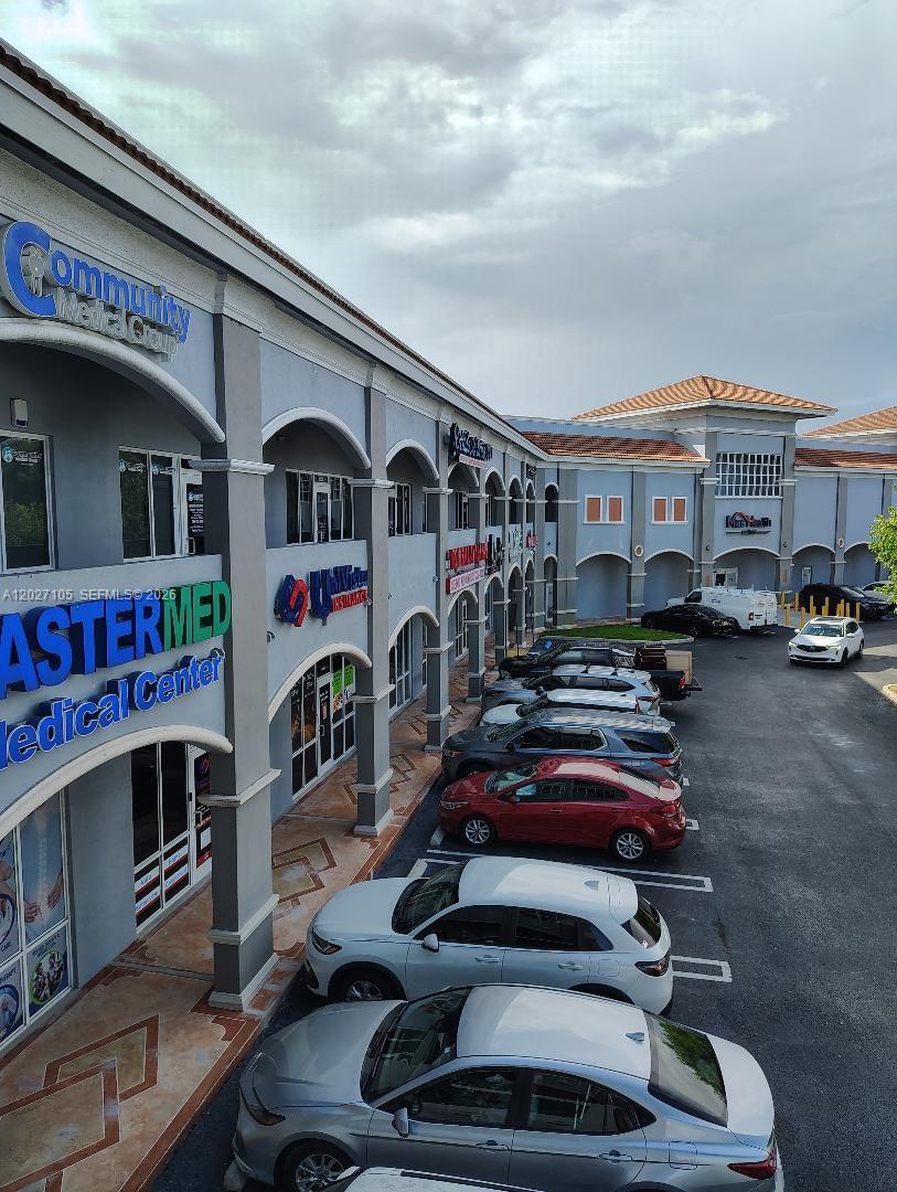 An exterior view of a multi-story commercial plaza with a parking lot in front — 14285 SW 42nd St # 211, Miami FL 33175, MIAMI, FL