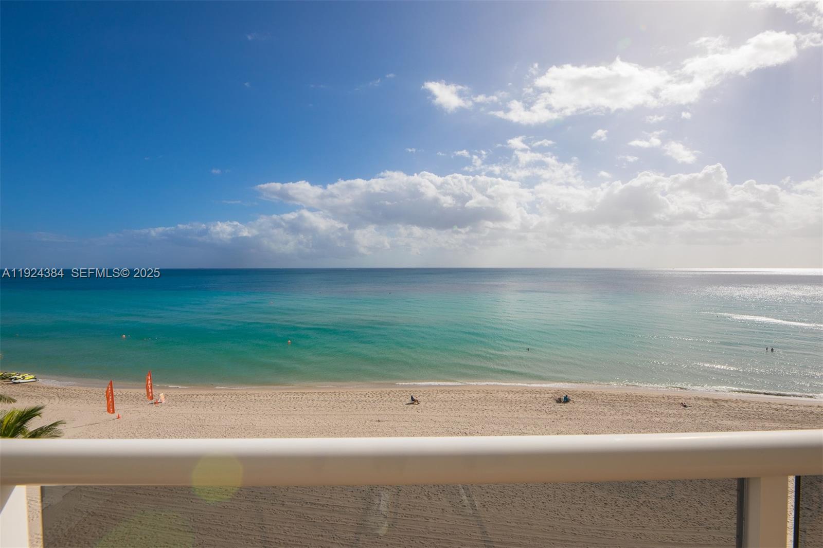 A view of the ocean and sandy beach from a balcony with a white railing — 3725 S Ocean Dr # 601, Hollywood FL 33019, HOLLYWOOD, FL