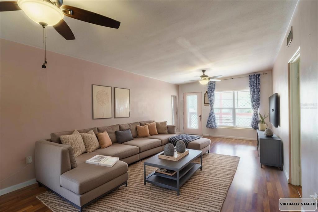 A living room with a large sectional sofa, coffee table, and wood-look flooring — 3523 SE 6TH STREET, OCALA, FL