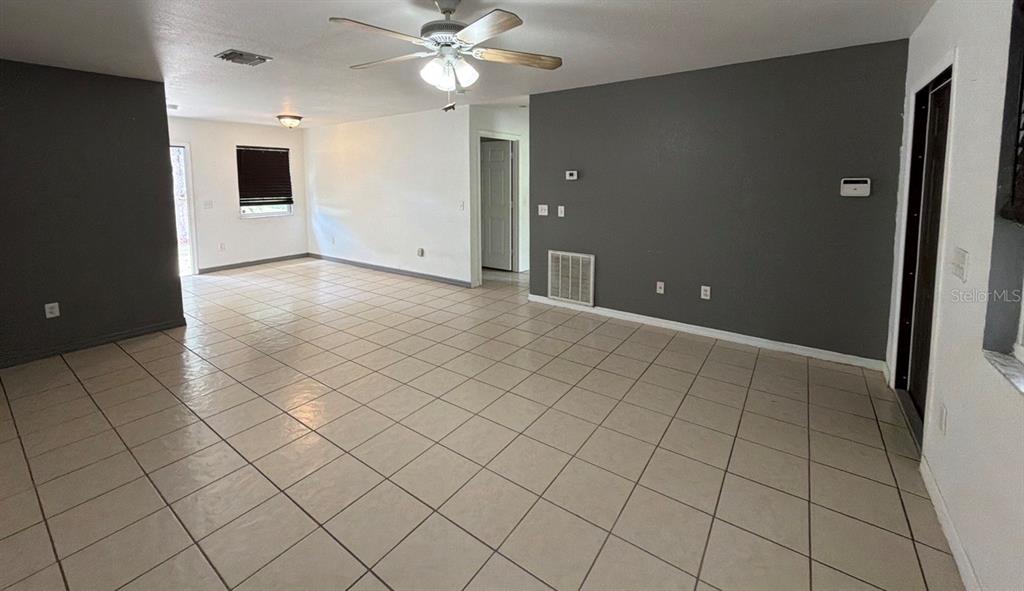 An open-concept living area features light-colored floor tiles and a dark gray accent wall — 2249 WOODMERE ROAD, VENICE, FL