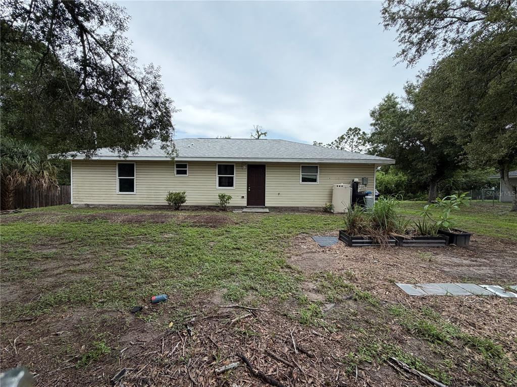 A kitchen features white cabinets, green countertops, tile flooring, and a dark exterior door — 2249 WOODMERE ROAD, VENICE, FL