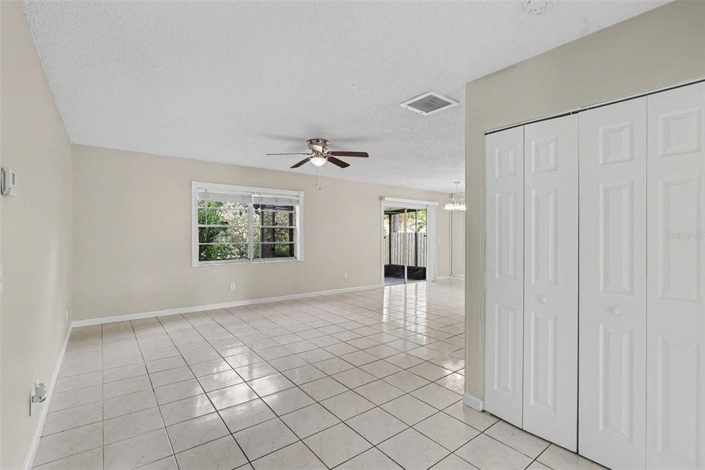 An open living area features light-colored tile flooring, a ceiling fan, and white closet doors — 301 REGAL PARK DRIVE, VALRICO, FL
