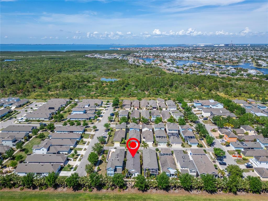 An aerial view shows a residential neighborhood with a red pin marking a specific house — 606 WINTERSIDE DRIVE, APOLLO BEACH, FL