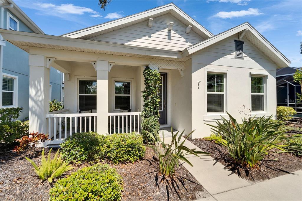 A single-story house with a white exterior, a covered front porch, and landscaped front yard — 606 WINTERSIDE DRIVE, APOLLO BEACH, FL