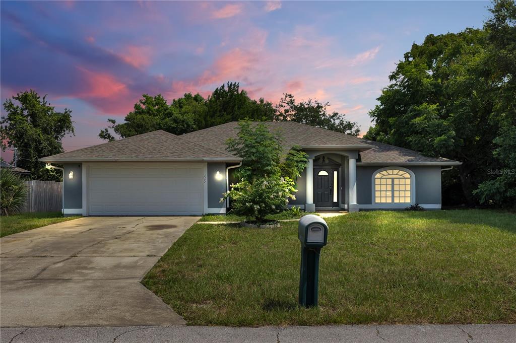 A single-story house with a gray exterior, a two-car garage, and a front lawn — 2752 N JULIET DRIVE, DELTONA, FL