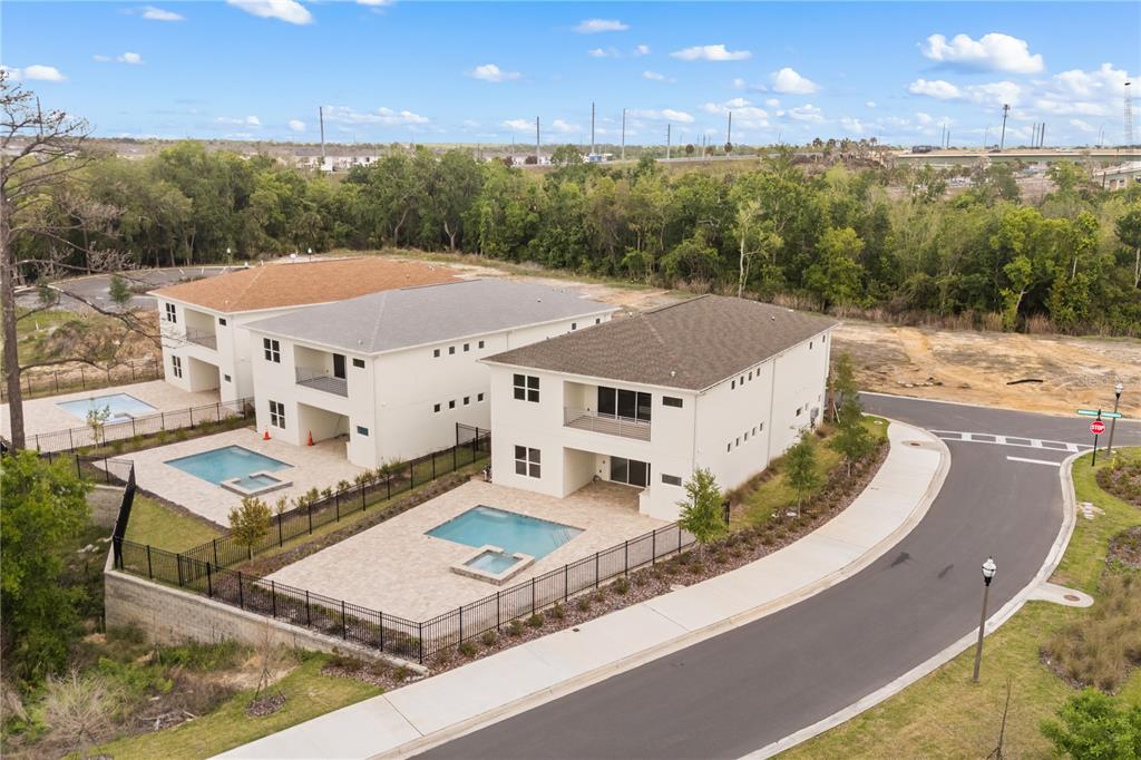 An aerial view shows three multi-story houses with private pools and fenced backyards — 7638 WHITEMARSH WAY, KISSIMMEE, FL