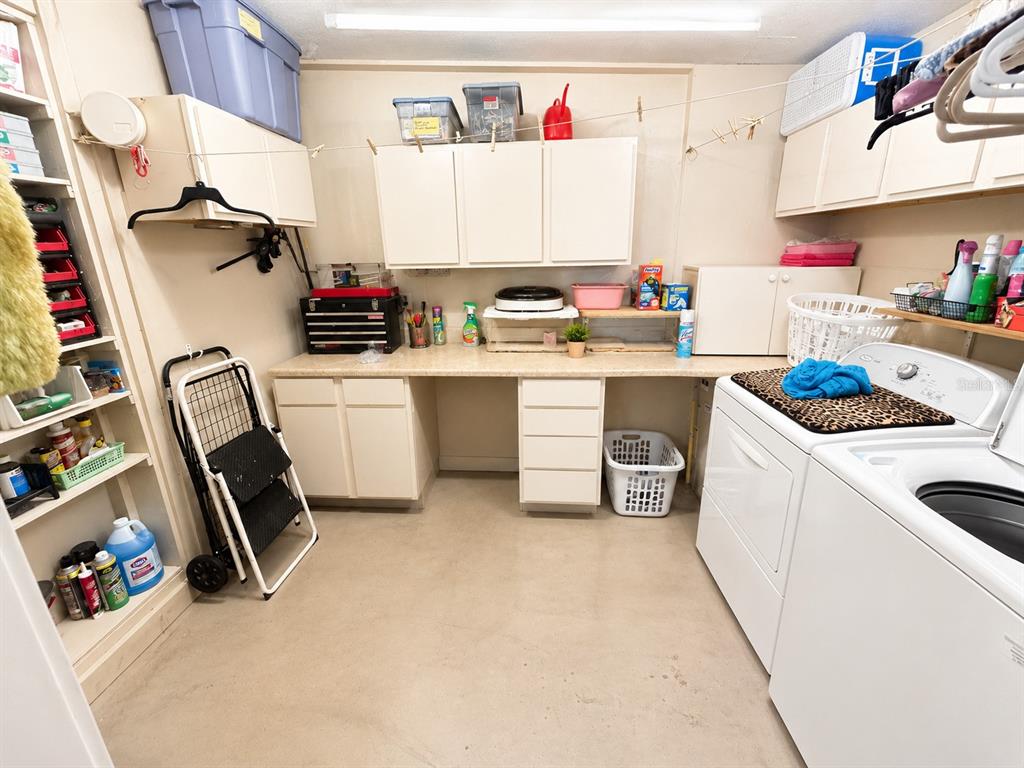 A laundry room with white cabinets, a countertop, and a washer and dryer — 608 DIXIE LANE, SOUTH DAYTONA, FL