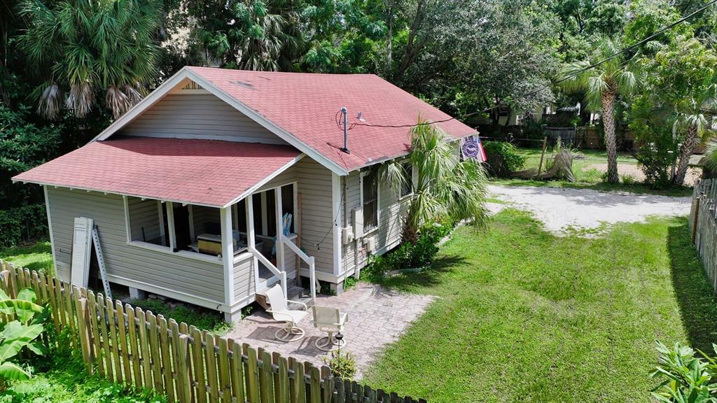 A yellow, single-story house with a front porch and brick steps stands on a grassy lot — 1569 7TH STREET, SARASOTA, FL