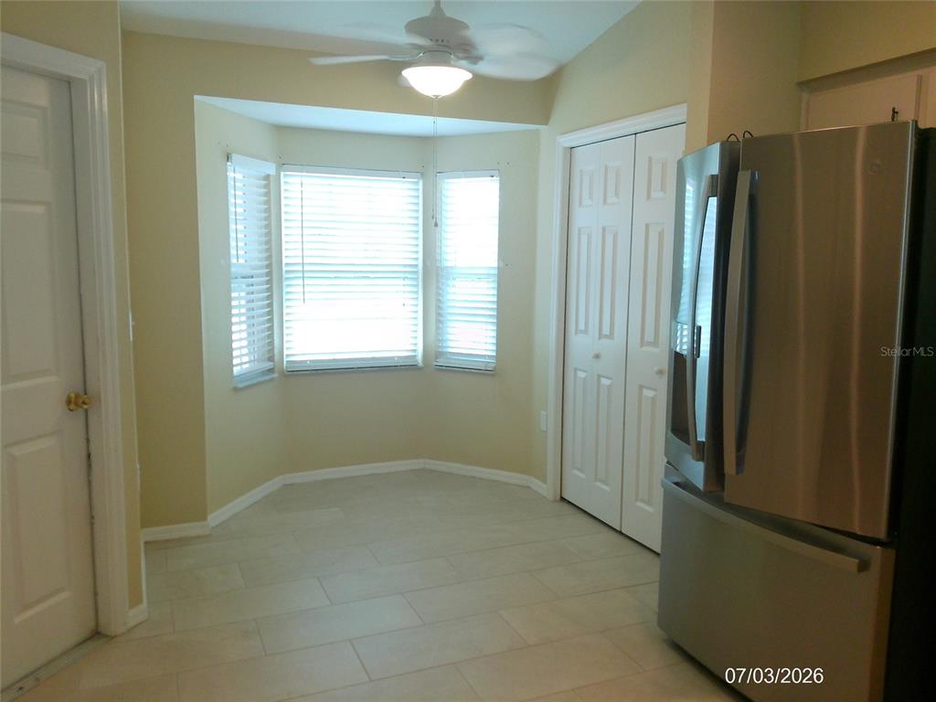 A kitchen breakfast nook features a bay window, tile flooring, and a ceiling fan — 3273 PEBBLEBROOKE BOULEVARD, LAKELAND, FL
