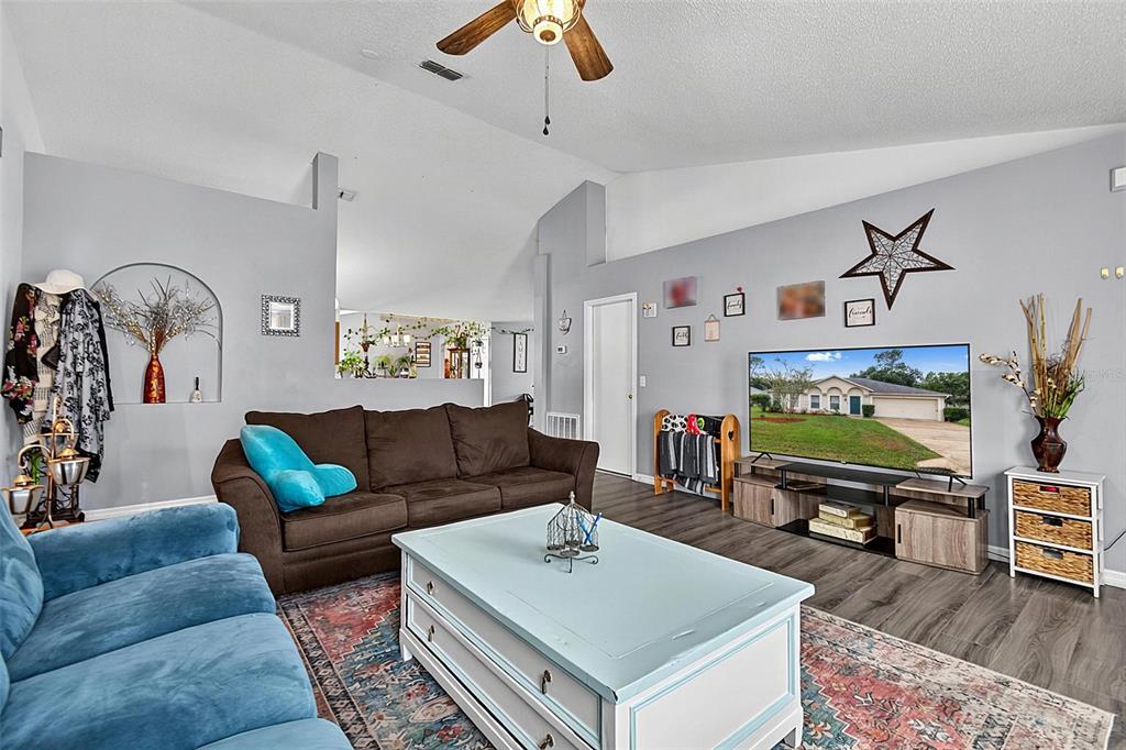A living room features a brown sofa, a blue sofa, and a light blue coffee table — 30 RYDER DRIVE, PALM COAST, FL