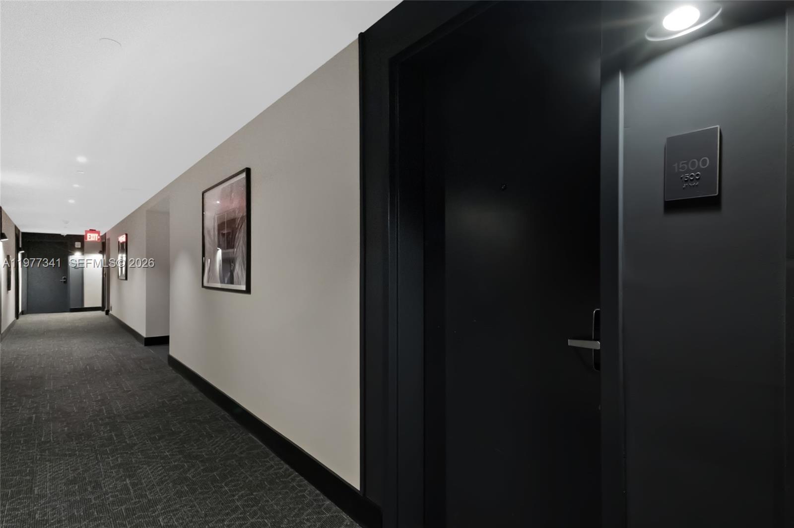 A dark-colored apartment door with unit number 1500 sits along a carpeted building hallway — 121 NE 5 ST # 1500, Miami FL 33132, MIAMI, FL