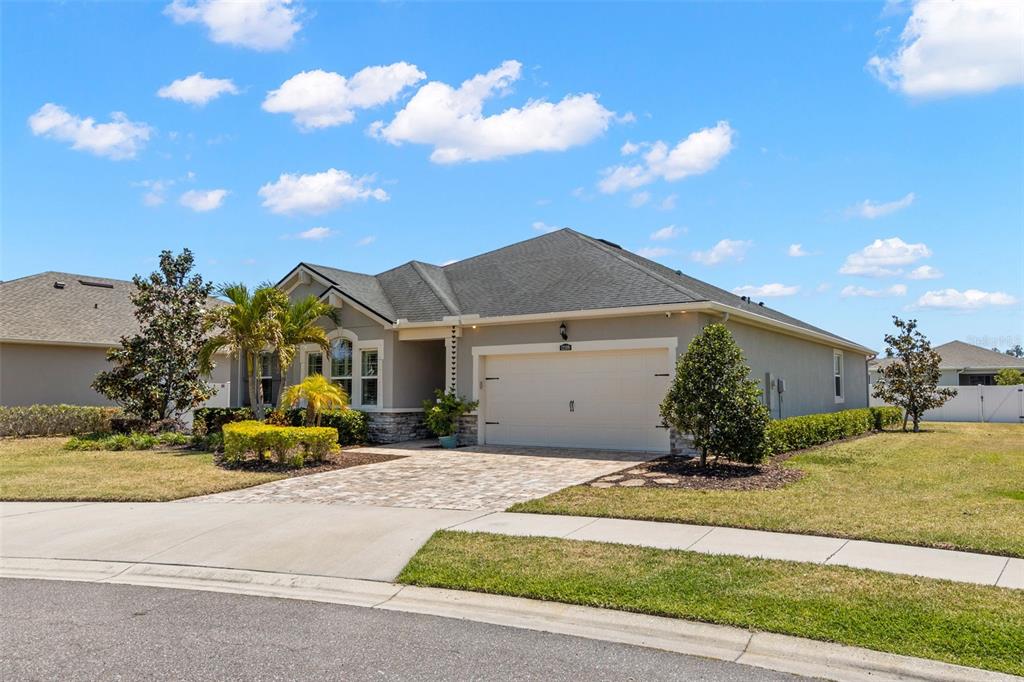 A single-story house with a beige stucco exterior, a two-car garage, and a paved driveway — 12109 NIGHT JASMINE COVE, RIVERVIEW, FL