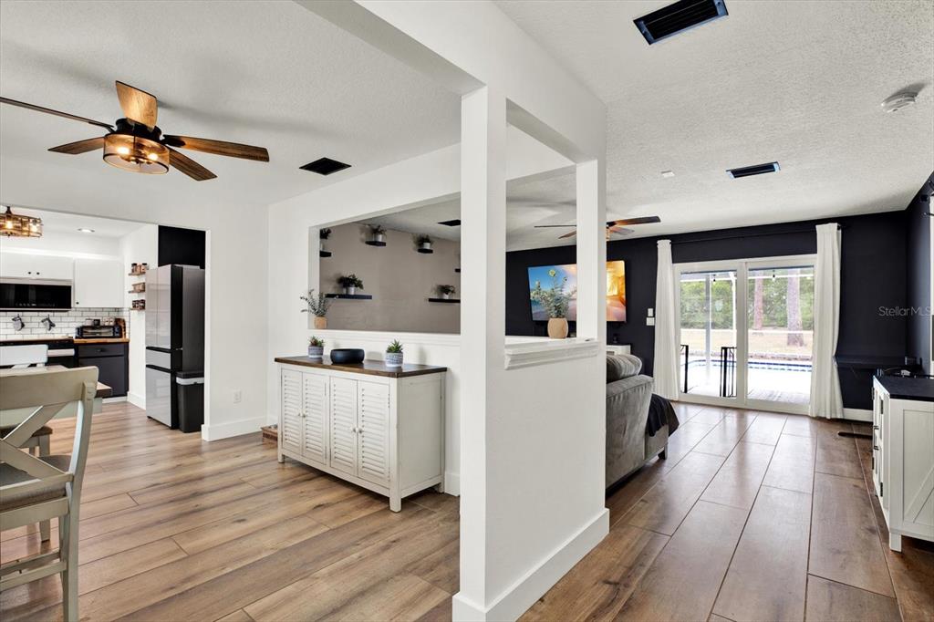 A view from a kitchen toward a living room with wood-look tile flooring — 4118 RAMONA DRIVE, SPRING HILL, FL
