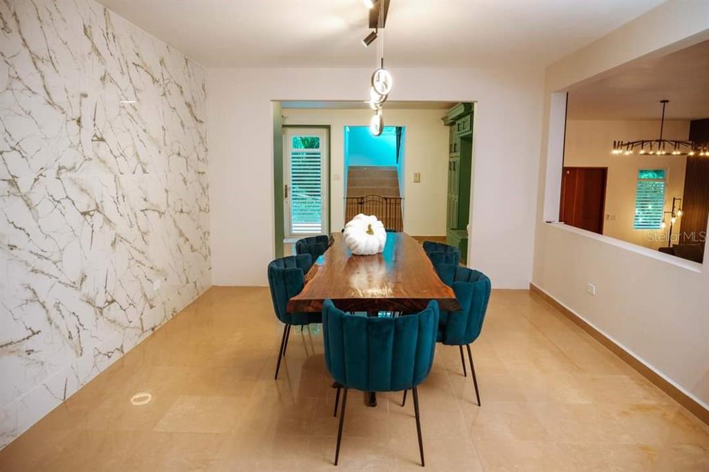 A dining room features a live-edge wood table, blue velvet chairs, and marble-patterned walls — CARR 799 KM 29.5 BO RIO CANAS SECT LA PONDEROSA UNIT 4, CAGUAS, PR