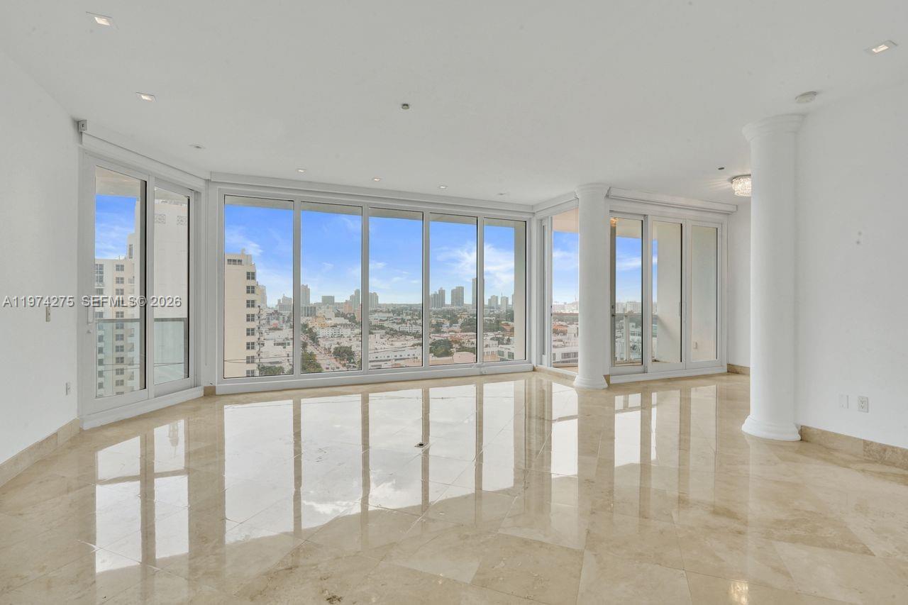 A bright, empty room features polished marble floors, white columns, and floor-to-ceiling windows — 100 Lincoln Rd, Miami Beach FL 33139, MIAMI BEACH, FL