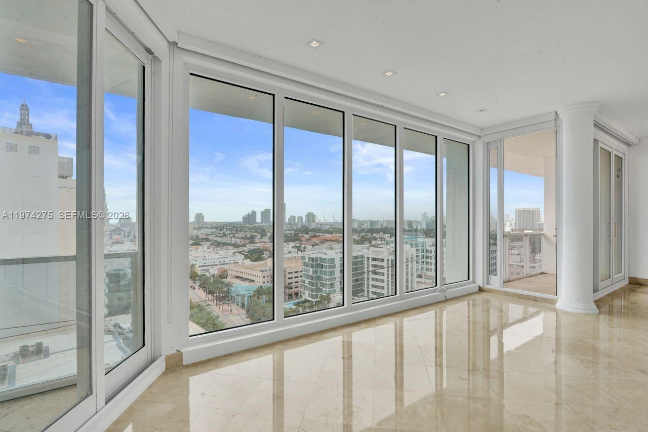 A bright room with marble floors features floor-to-ceiling windows overlooking a city skyline — 100 Lincoln Rd, Miami Beach FL 33139, MIAMI BEACH, FL