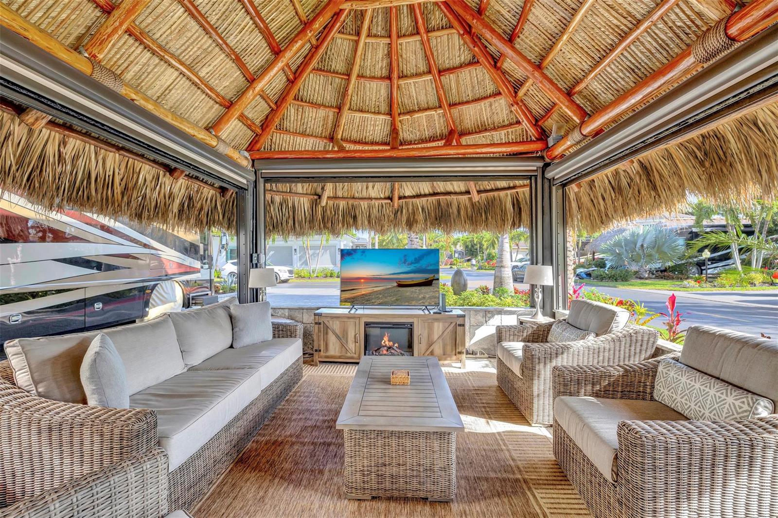 A thatched-roof outdoor living space features wicker furniture, a fireplace, and a television — 291 N Cortez Drive # 291, Margate FL 33068, MARGATE, FL