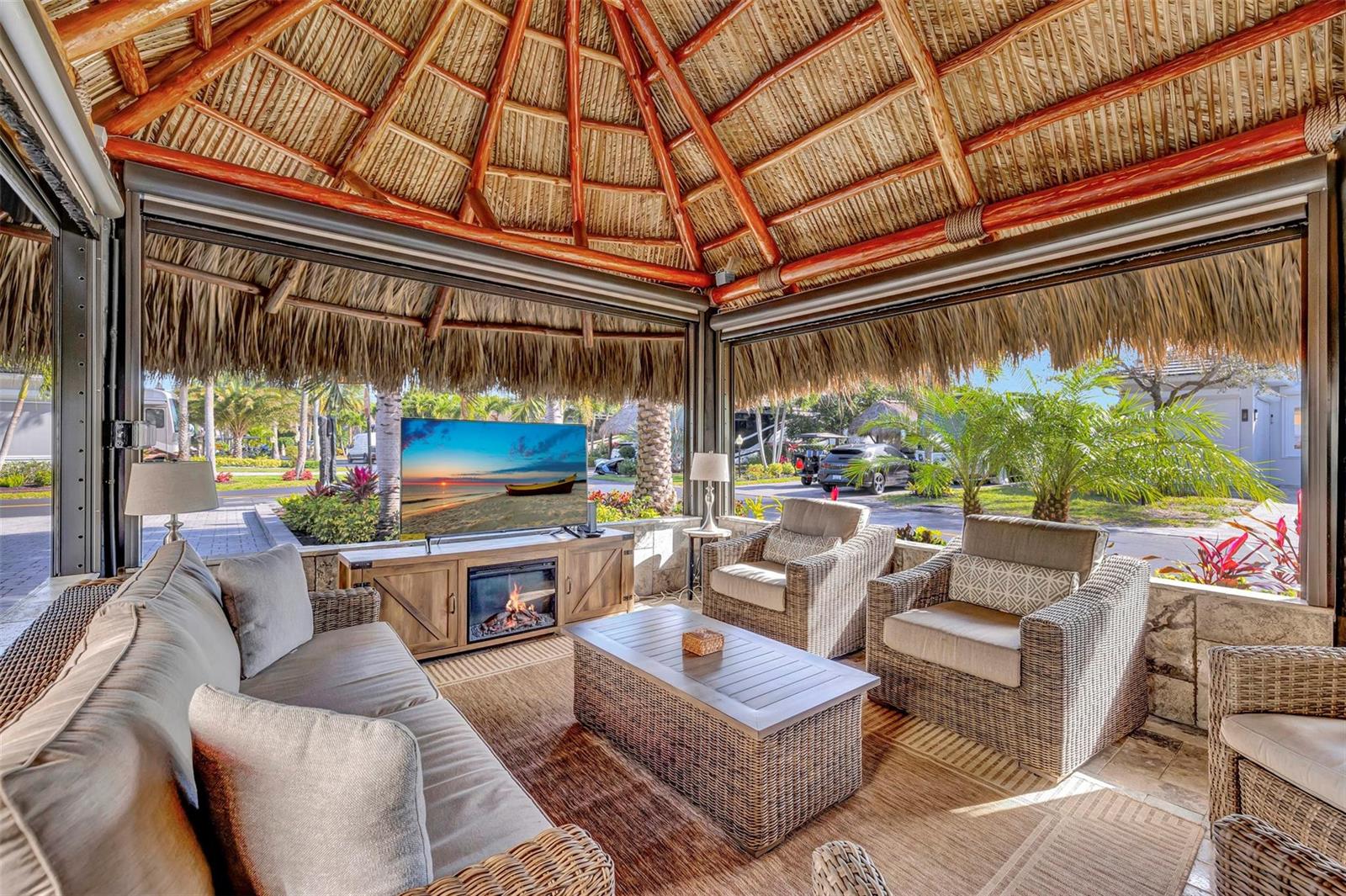 An open-air patio with a thatched roof, wicker furniture, a fireplace, and a television — 291 N Cortez Drive # 291, Margate FL 33068, MARGATE, FL