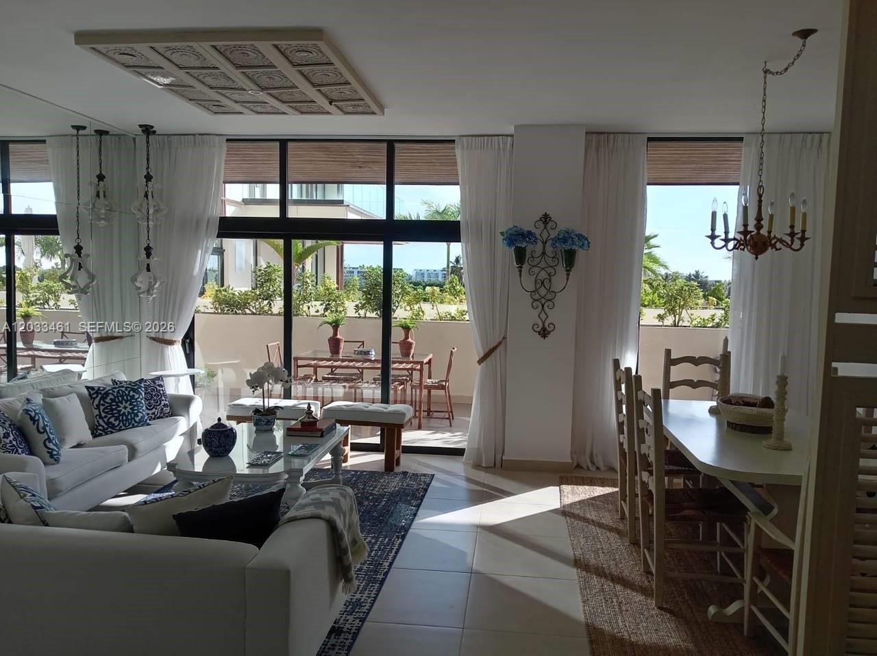 A living and dining area with white furniture, large windows, and a balcony with seating — 1 1 # 205, FL, FL