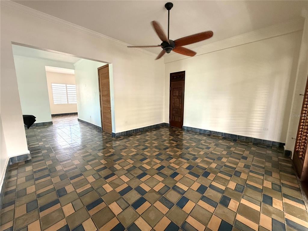 An empty room features a patterned tile floor, a ceiling fan, and two wooden doors — 1507 LAS MARÍAS, SAN JUAN, PR