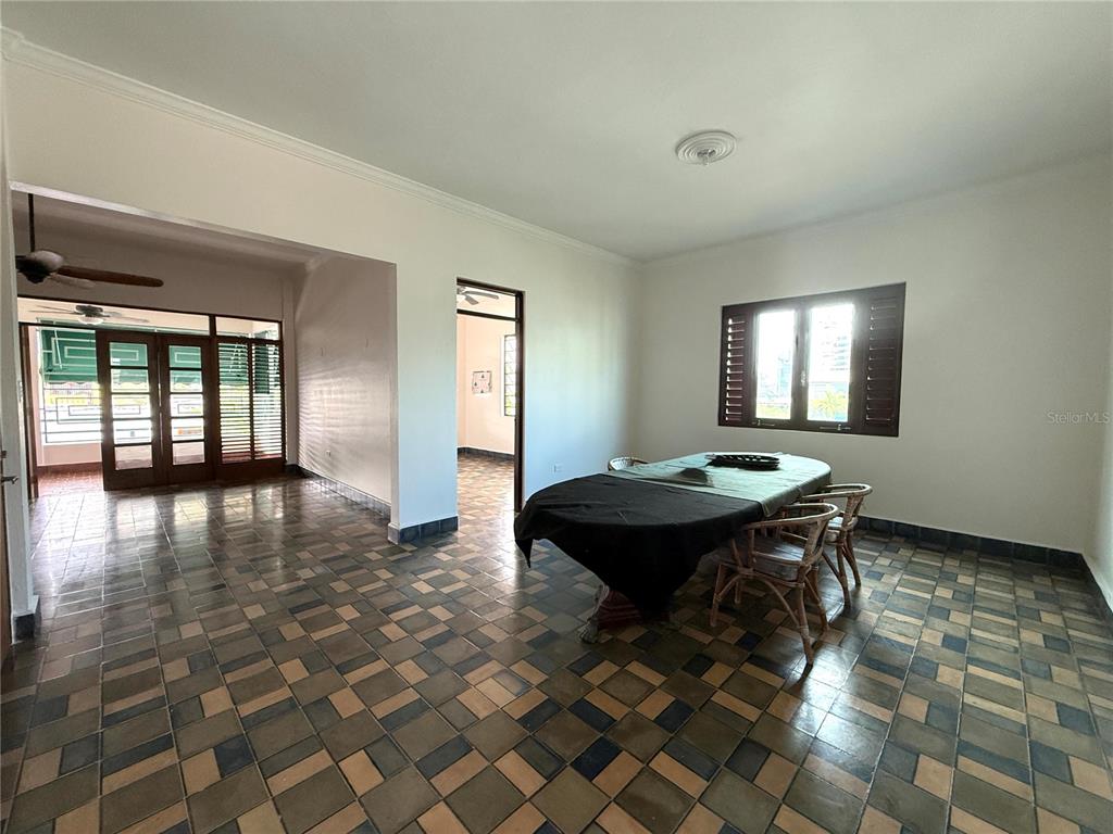 A dining room with tiled floors, a dark-covered table, and a doorway to another room — 1507 LAS MARÍAS, SAN JUAN, PR