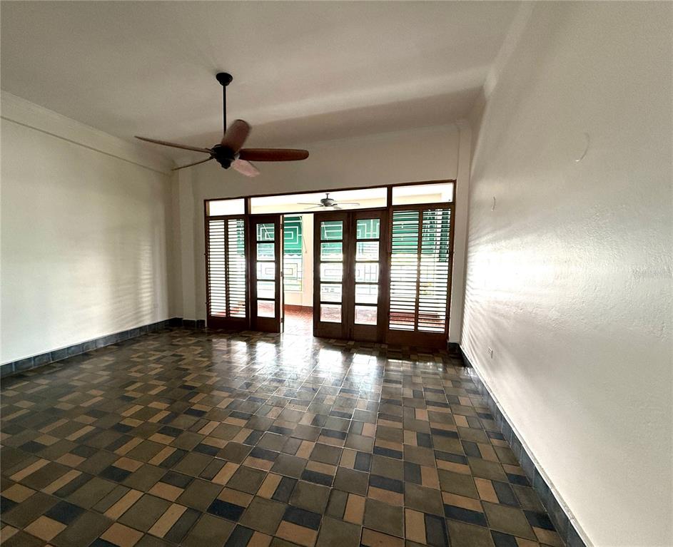 An empty room features a tiled floor, white walls, and a wooden ceiling fan — 1507 LAS MARÍAS, SAN JUAN, PR