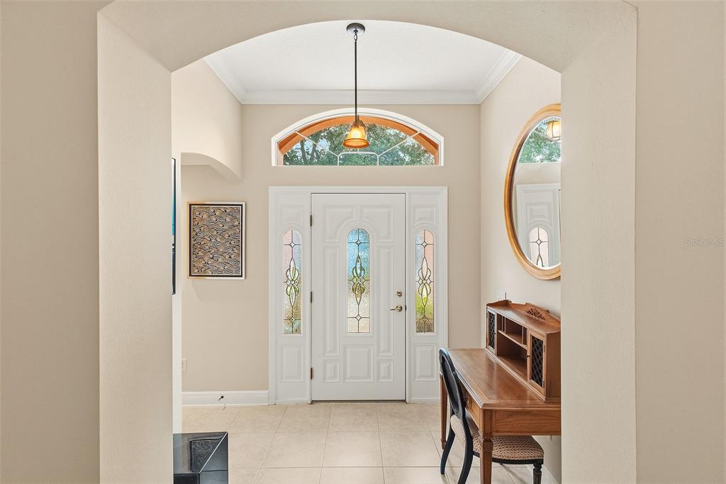 An entryway features a white front door with sidelights, a transom window, and a wooden desk — 2252 CENTRAL STREET, THE VILLAGES, FL