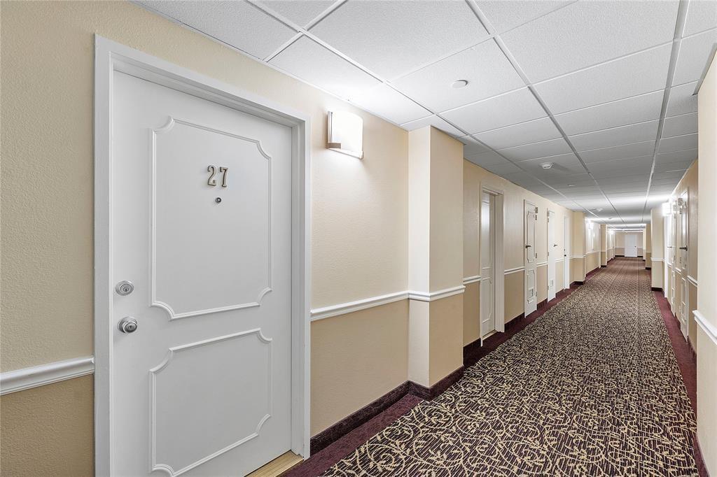A long hotel-style hallway features patterned carpet, beige walls, and white doors with numbers — 405 N Ocean Boulevard, Pompano Beach FL 33062, POMPANO BEACH, FL