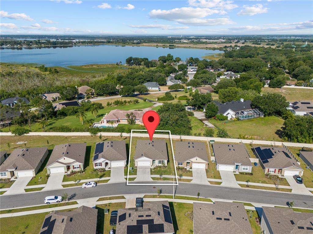 An aerial view shows a suburban house with a red location pin on a residential street — 571 TANARO LANE, HAINES CITY, FL