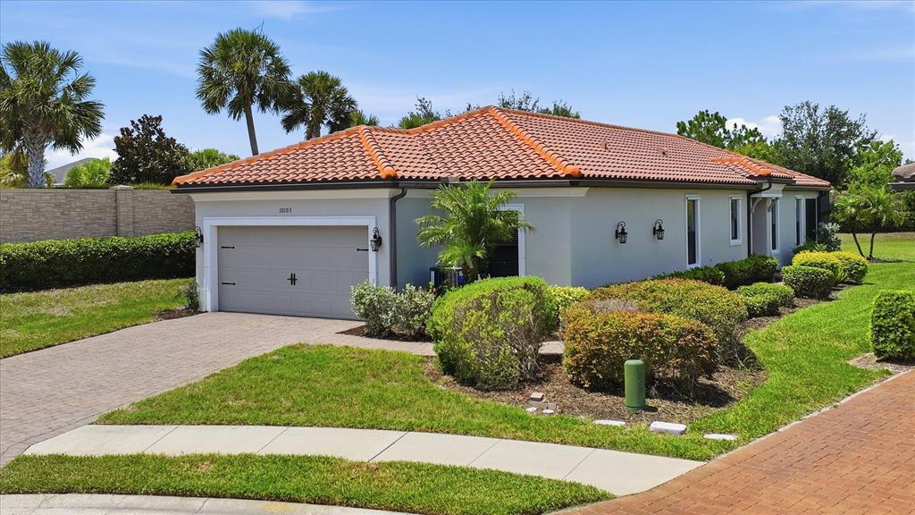 A single-story house with a tile roof, gray stucco exterior, and a two-car garage — 10103 SAINT FRANCIS TERRACE, PALMETTO, FL