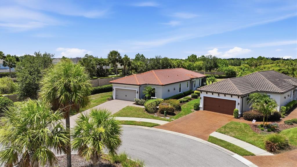 An aerial view shows two single-story houses with tiled roofs and paved driveways — 10103 SAINT FRANCIS TERRACE, PALMETTO, FL